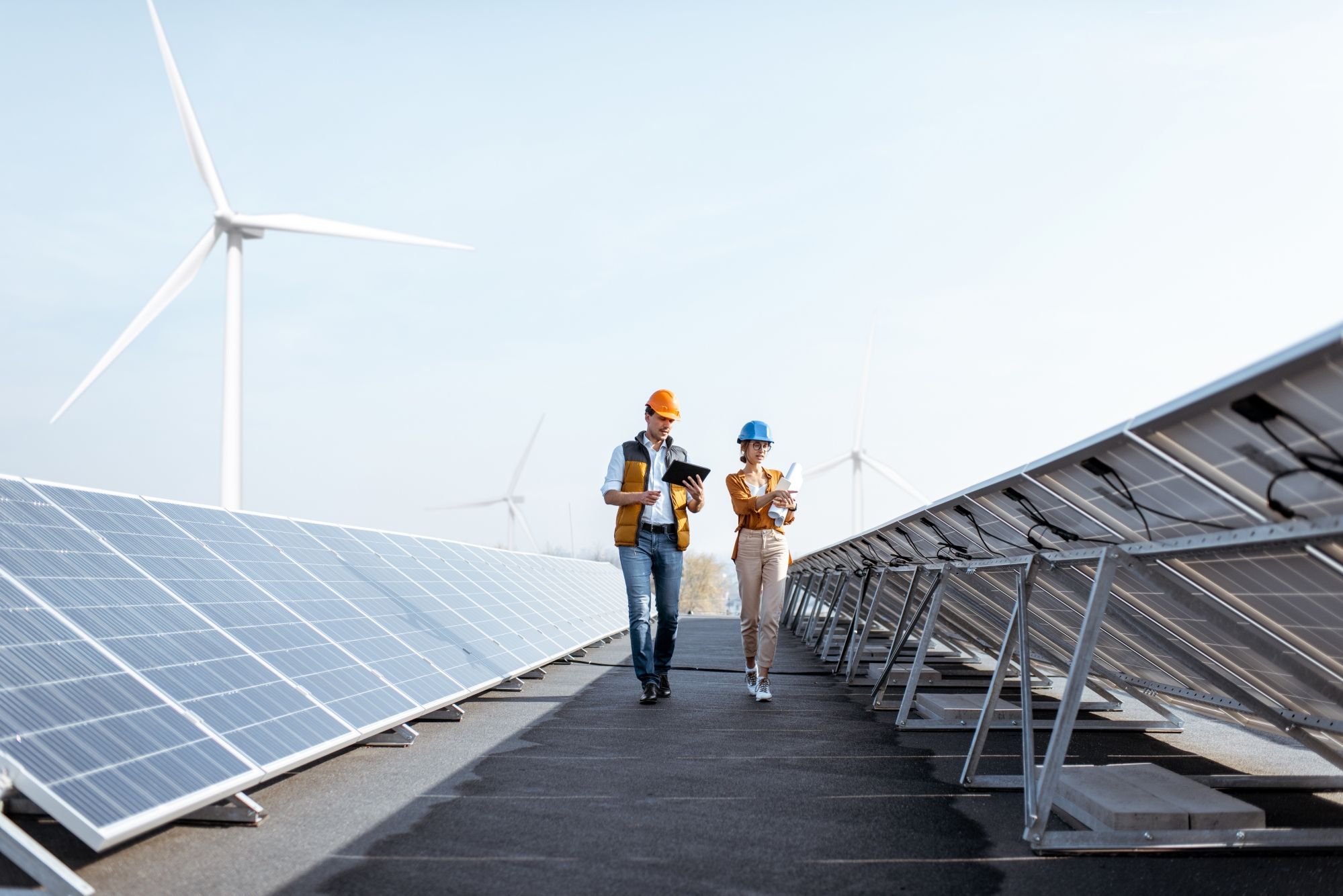Man and woman with solar panels and wind turbine